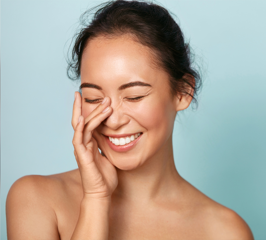 Model Smiling holding face blue background